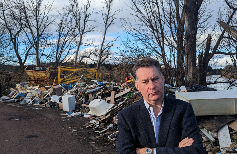 Murdo beside fly-tipping near the River Tay, Perth 