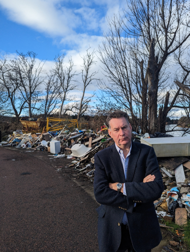 Murdo beside fly-tipping near the River Tay, Perth 